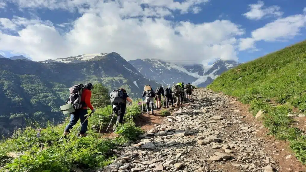 Hikers ascend lush trails towards the towering Elbrus - B4Experience.