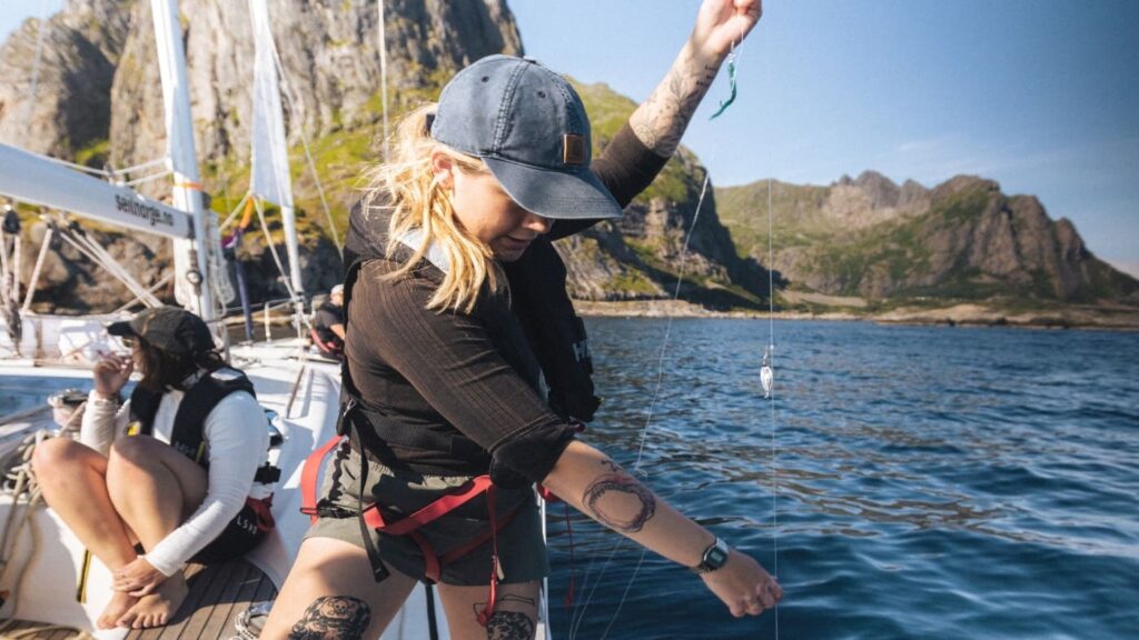 Woman on board a sailboat fishing for cod