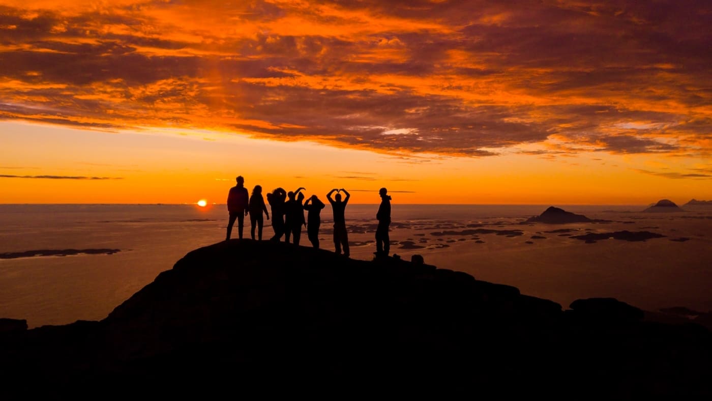 Sunset of incredible colors with a group of people on top of a mountain