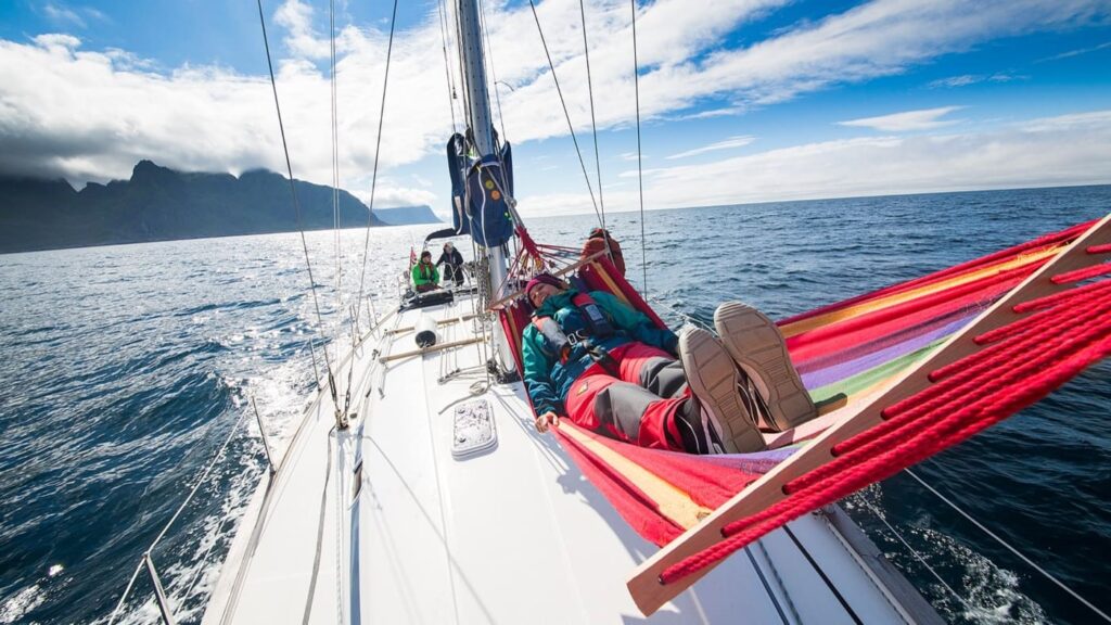 Man enjoying sailing aboard a hammock between masts