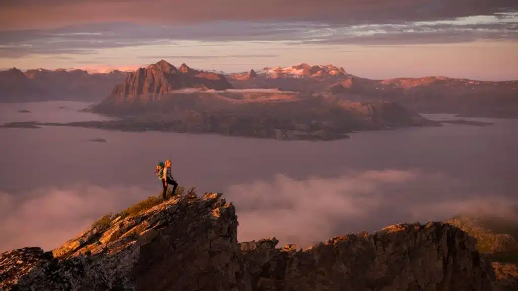 Woman hiker on top of mountain, wonderful view of fjord