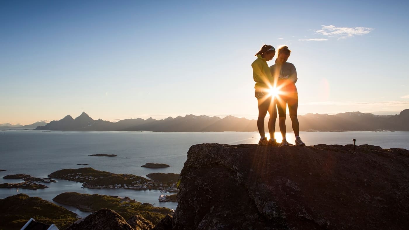 Two women on a high mountain with a ray of sunshine