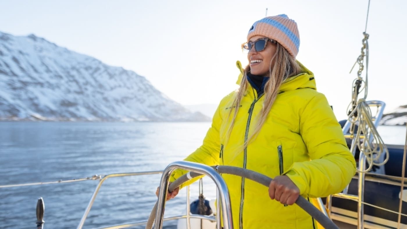 Smiling woman at the helm of a sailboat in Norway