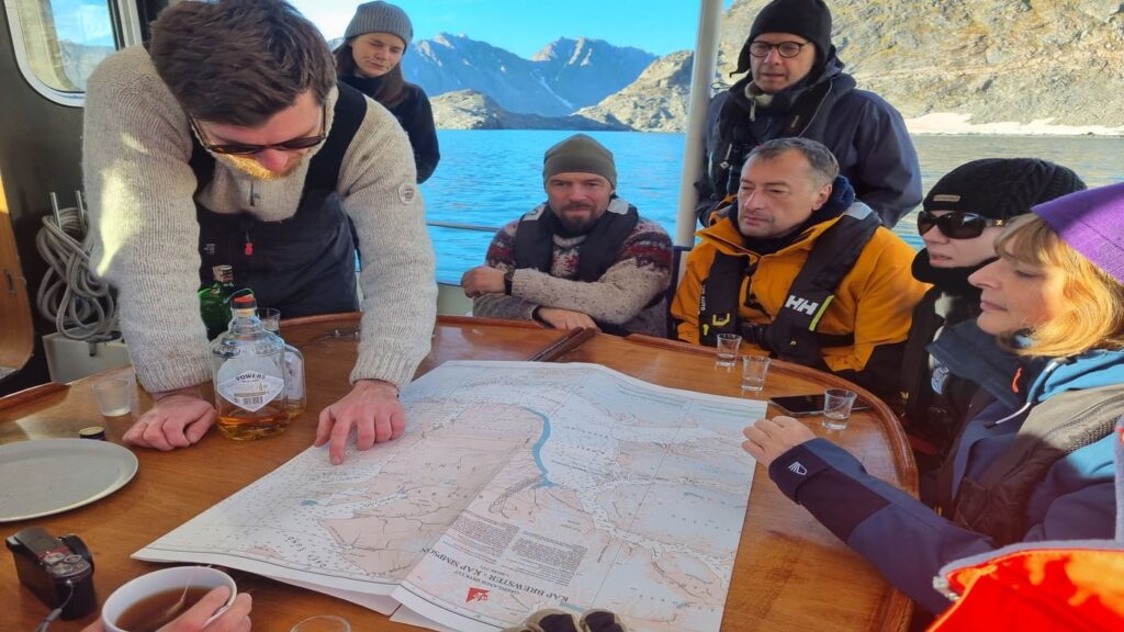 Crew consulting the navigation chart on the deck table