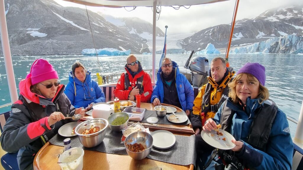 Crew eating on deck with incredible views of the fjord