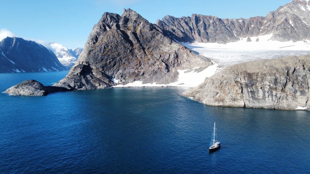 Landscape of sailboat in the sea and snowy mountains