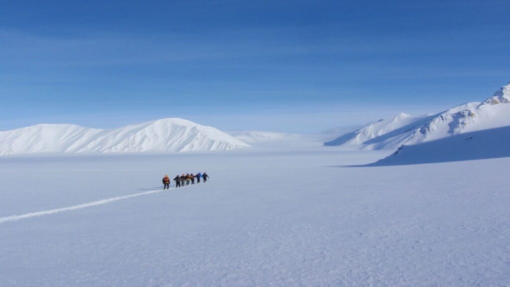 Group of backcountry skiers crossing a glacier in wild Svalbard