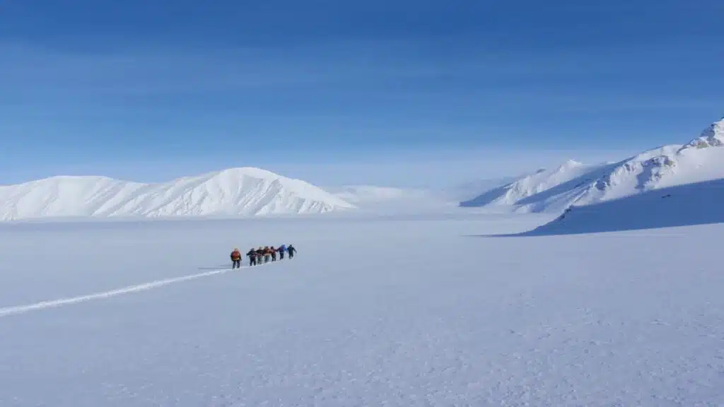 Group of backcountry skiers crossing a glacier in wild Svalbard