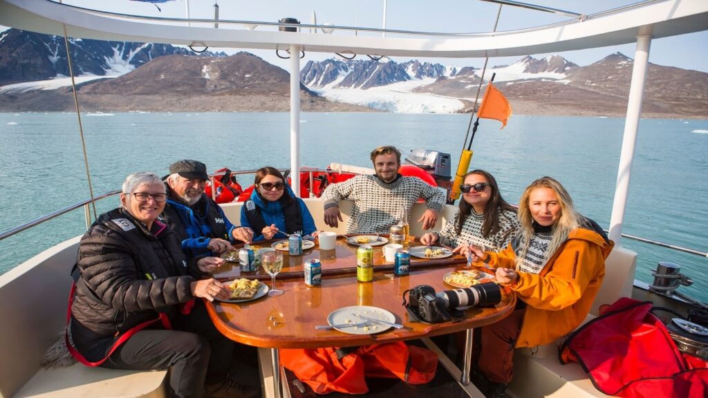 Group of people enjoying a meal on the deck of a sailboat in Norway