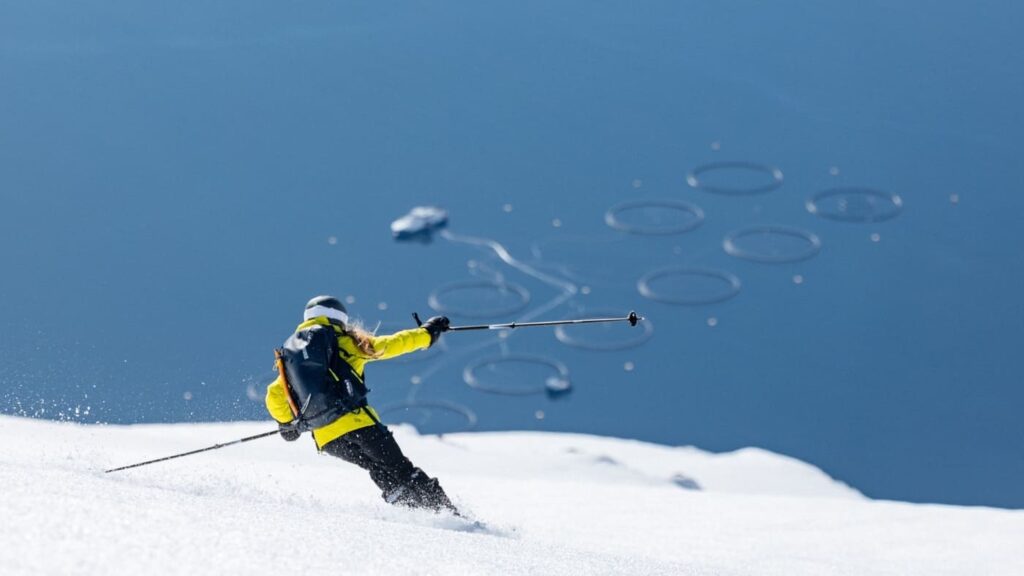 Skier begins to descend a hill with a view of the sea below