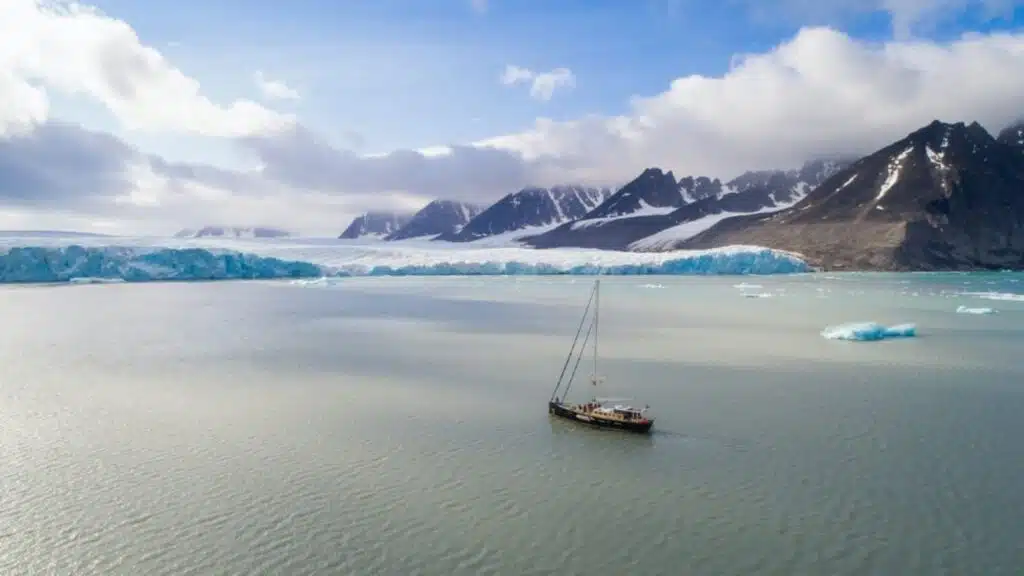 Sailboat approaching the polar ice shelf at the North Pole