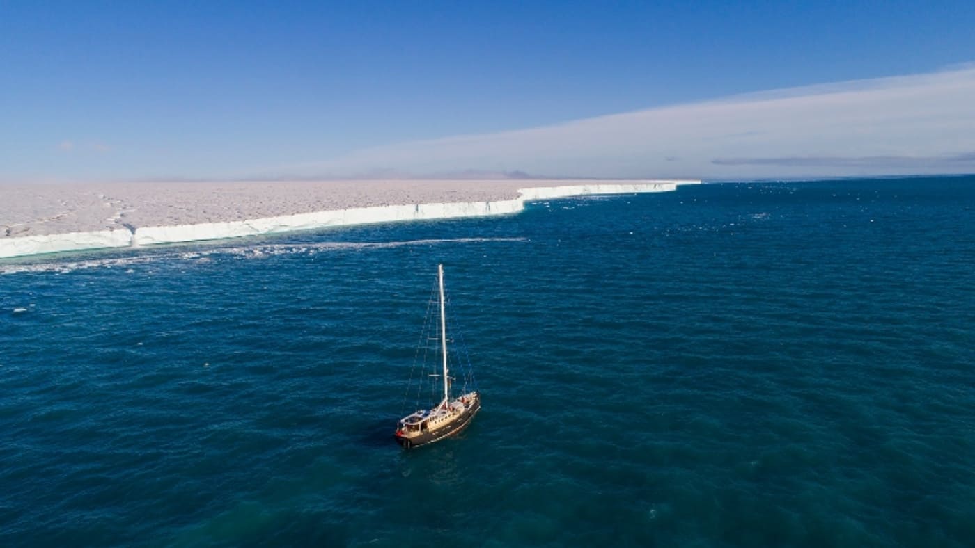 Sailboat sailing along the ice floe of the North Pole