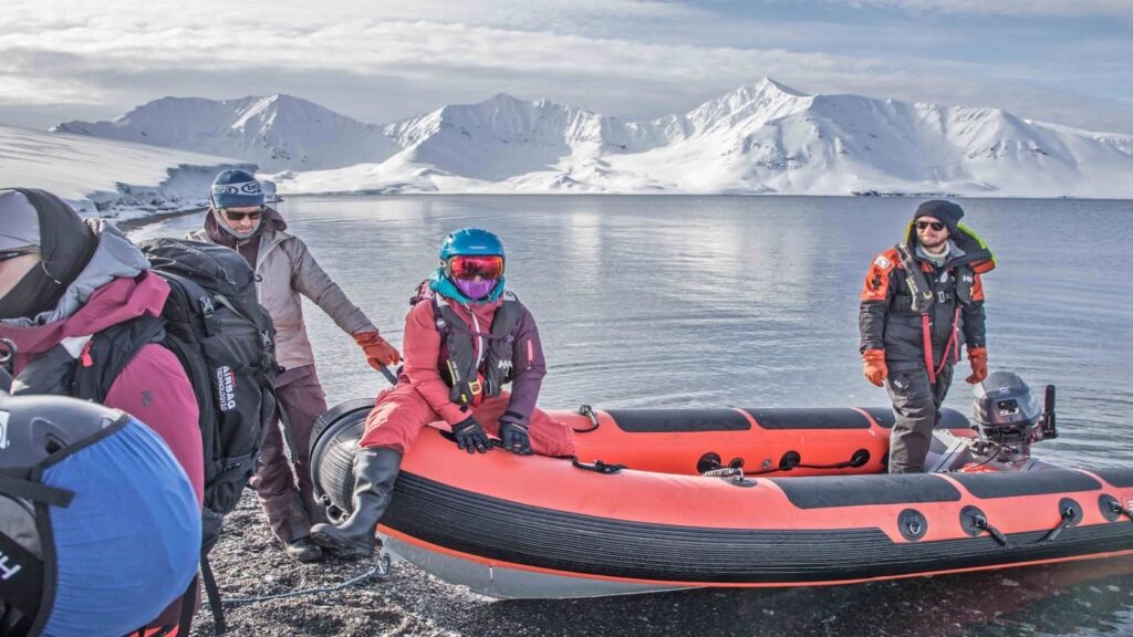 Zodiac with skiers lands on the beach