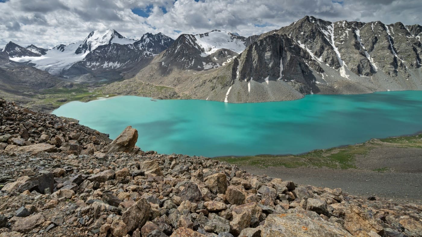 Stunning turquoise lake surrounded by rugged mountains on the Ala Kul Trek with B4Experience