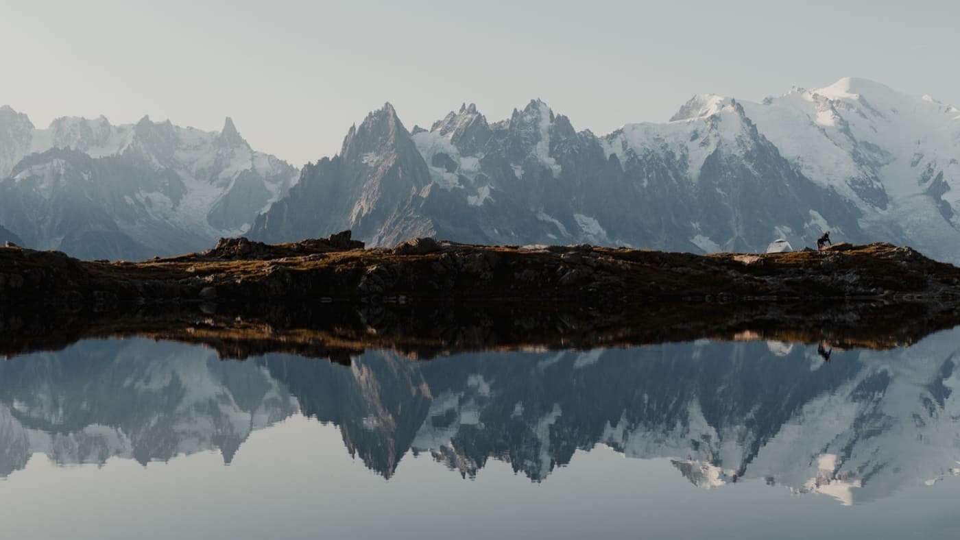 Mountain range reflected in a calm alpine lake.