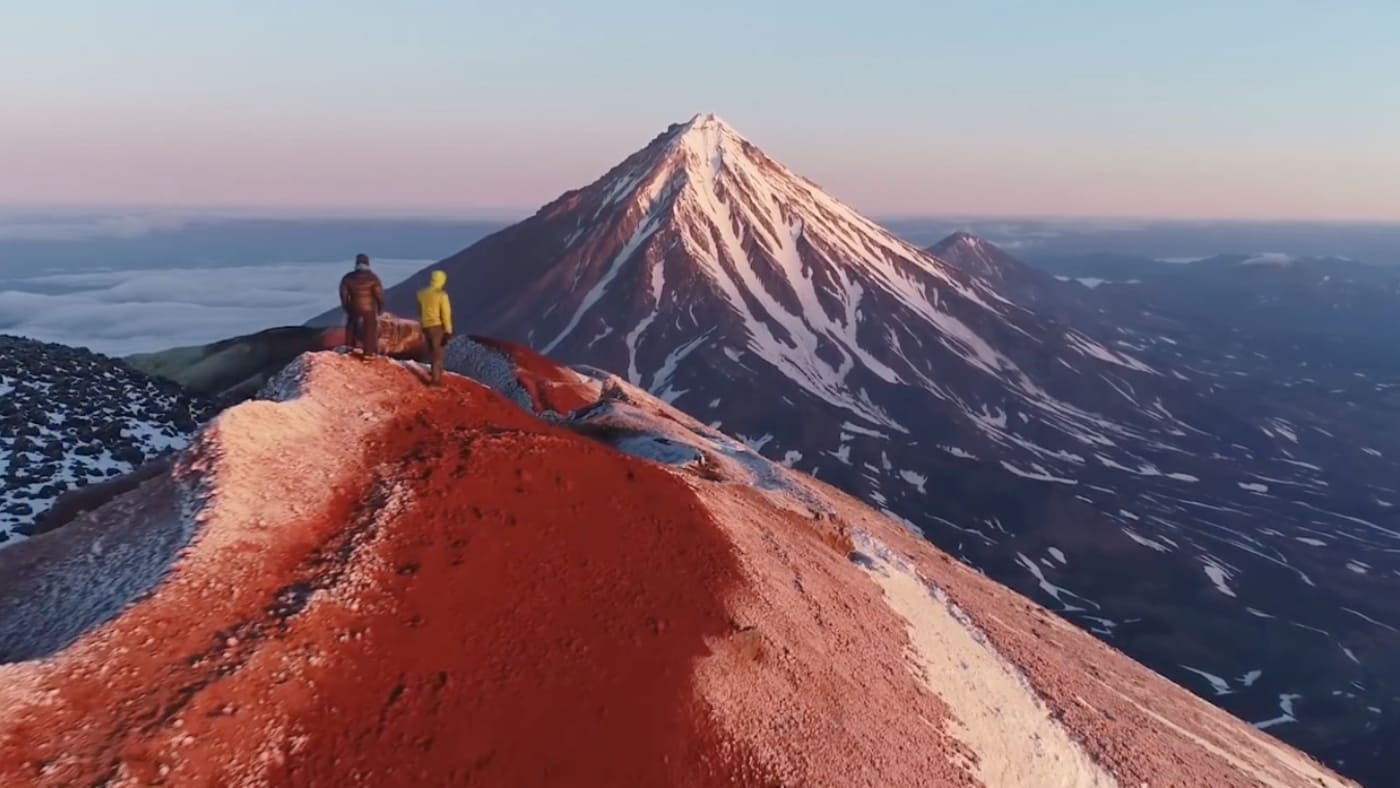 Climbers traverse a volcanic ridge at sunrise in Kamchatka with B4Experience