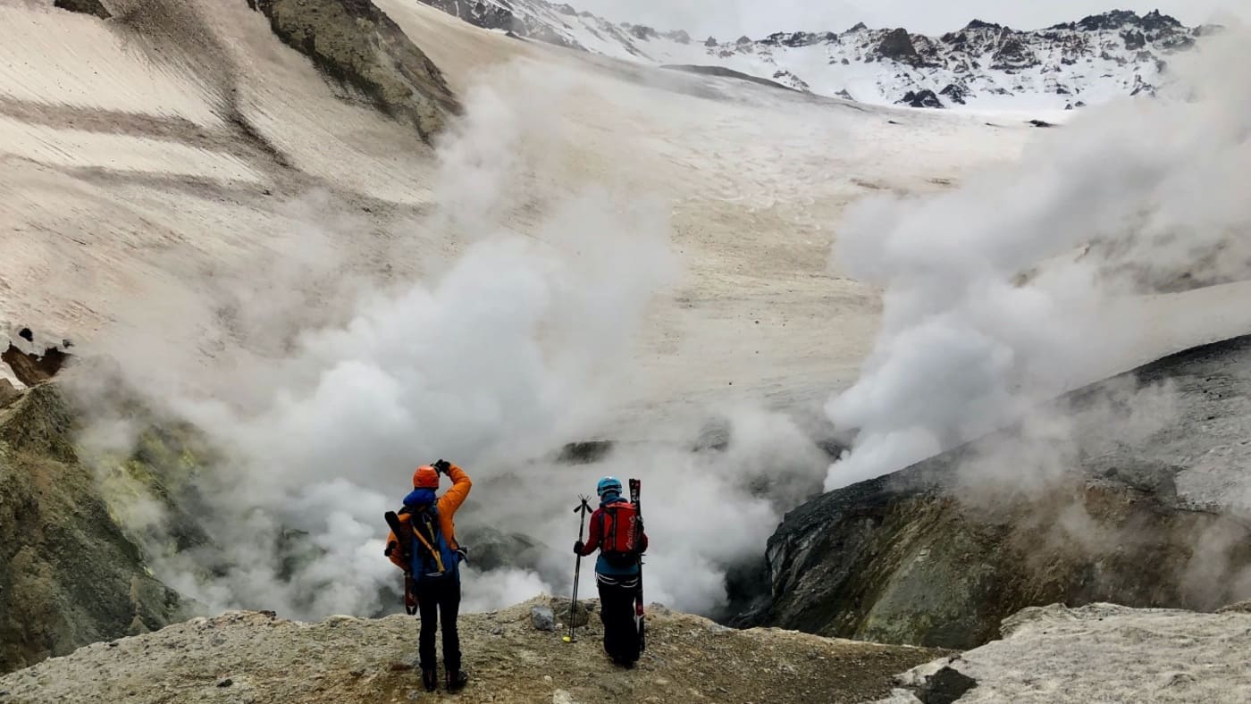 Hikers exploring steaming volcanic terrain in Kamchatka with B4Experience