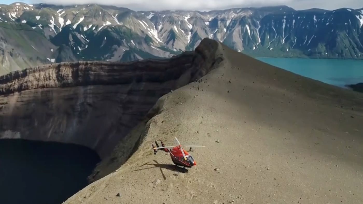 A helicopter lands on the rim of volcanic crater in Kamchatka with B4Experience