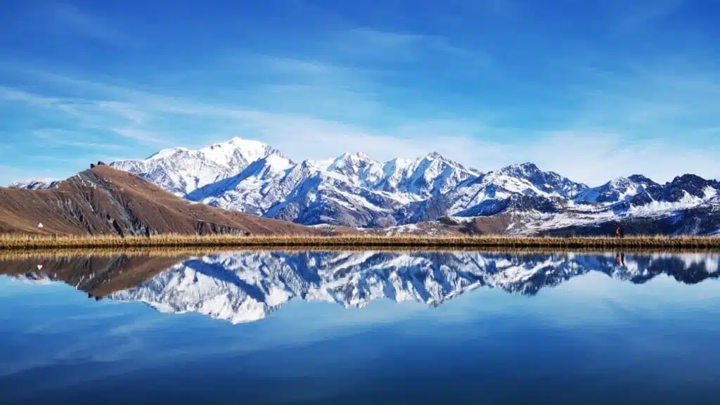 Snowy mountains reflected in a crystal-clear lake.