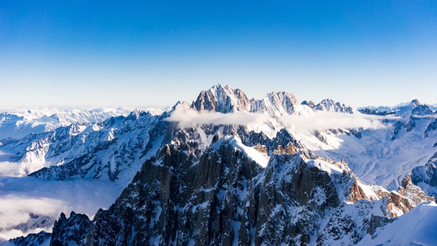 Snowy ridges rise above the clouds, marking the ascent's beginning with B4Experience