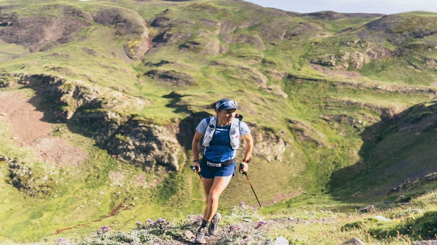 Trail runner navigating green mountain terrain.