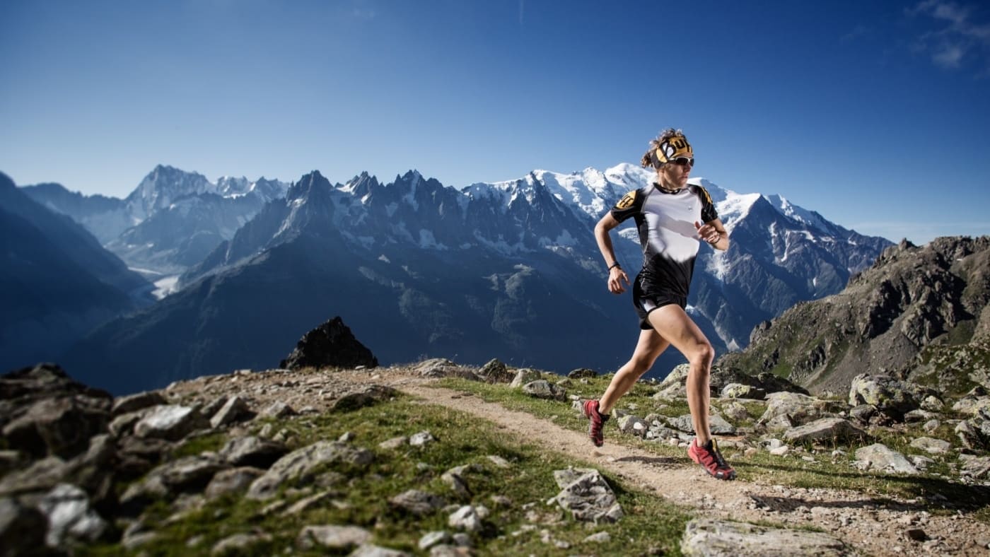 Trail runner on a rocky apline path with mountain views, Nuria Picas - B4Experience.