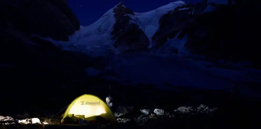 Glowing tent under a dark mountainous sky in Pakistan with B4Experience