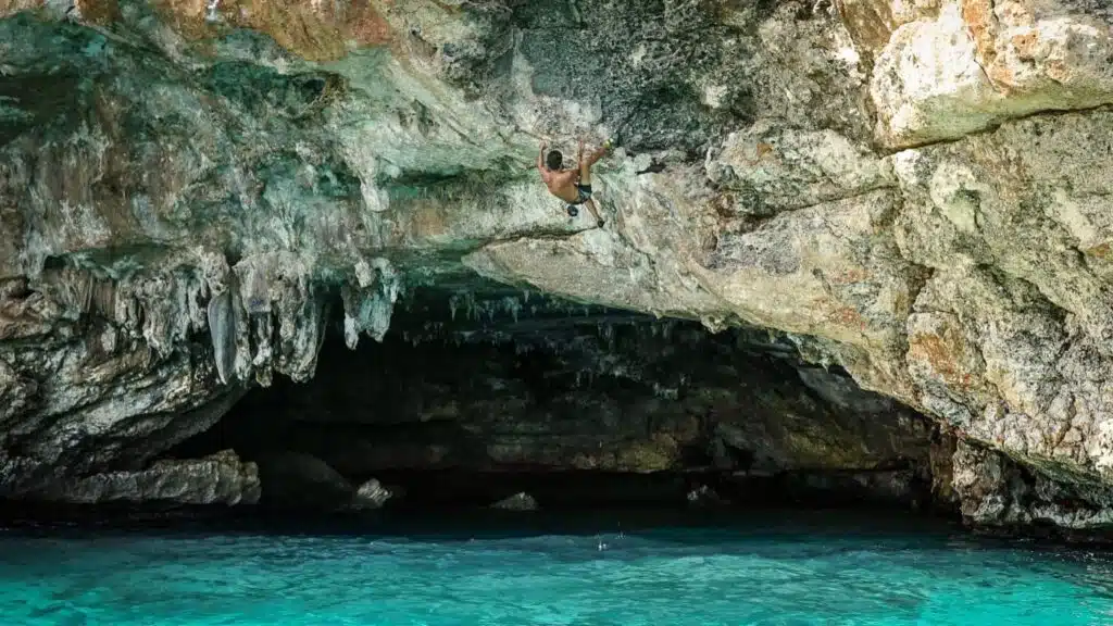 A climber deep water soloing in Cala Varques, Mallorca with B4Experience