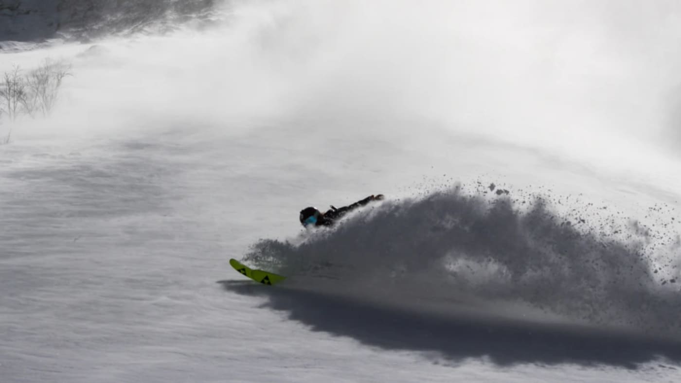 Skier carving through deep powder in Japan with B4Experience