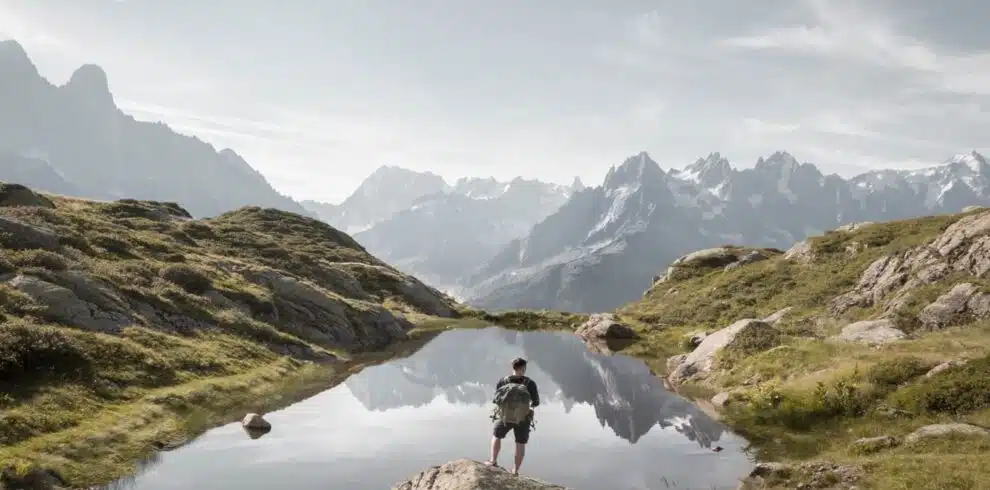 A trekker walking beside an alpine lake in Chamonix with B4Experience