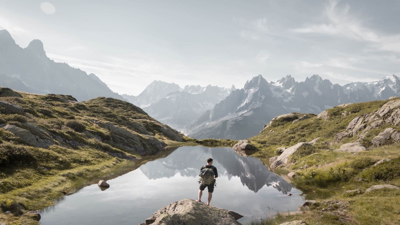 A trekker walking beside an alpine lake in Chamonix with B4Experience