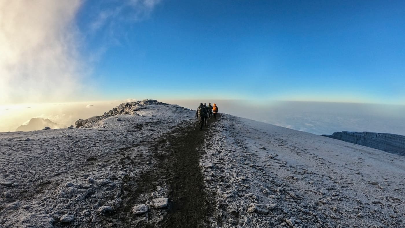 Hikers reaching the snowy summit of Kilimanjaro with B4Experience