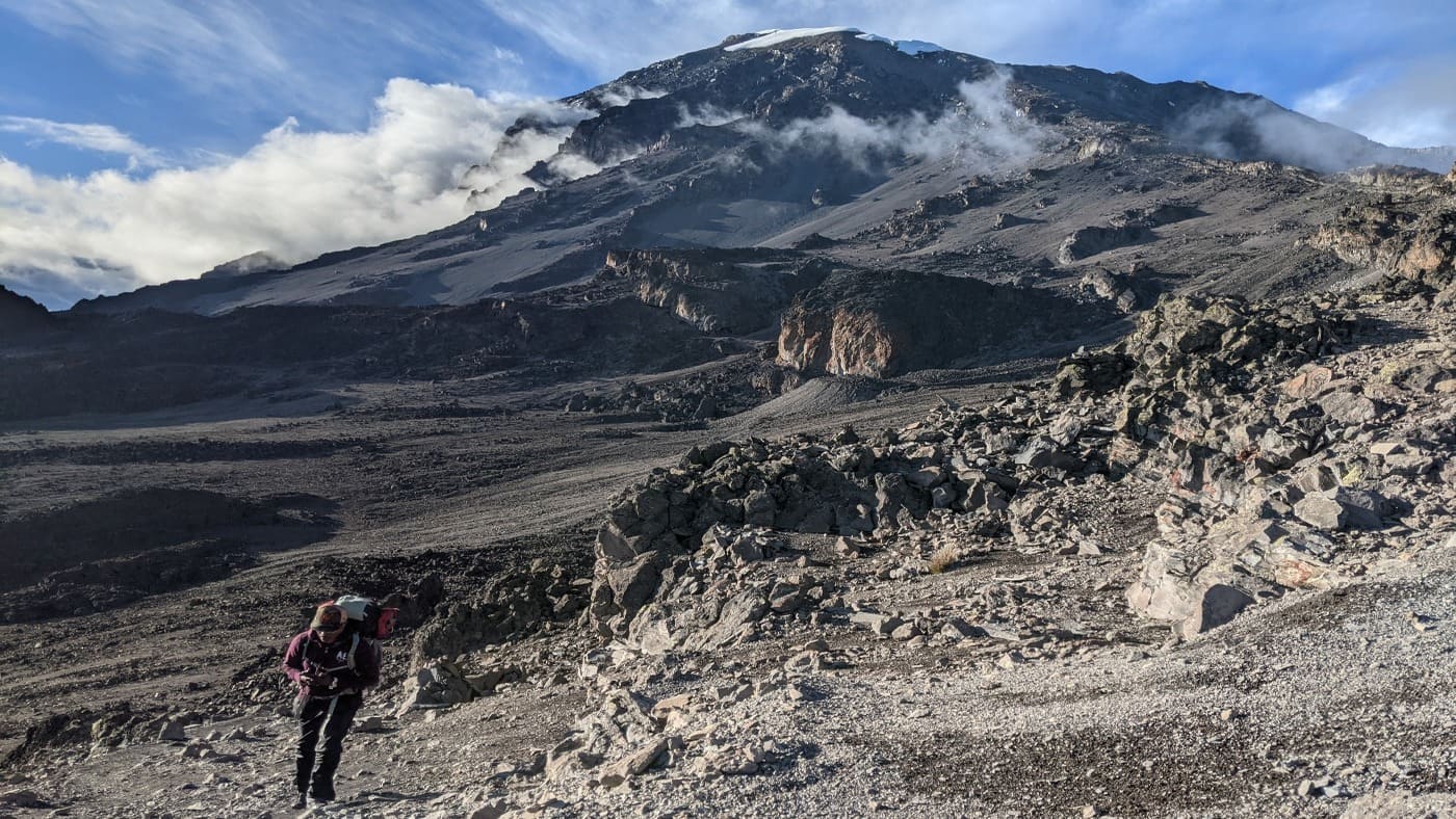 Trekker ascending Kilimanjaro's rugged volcanic slopes with B4Experience