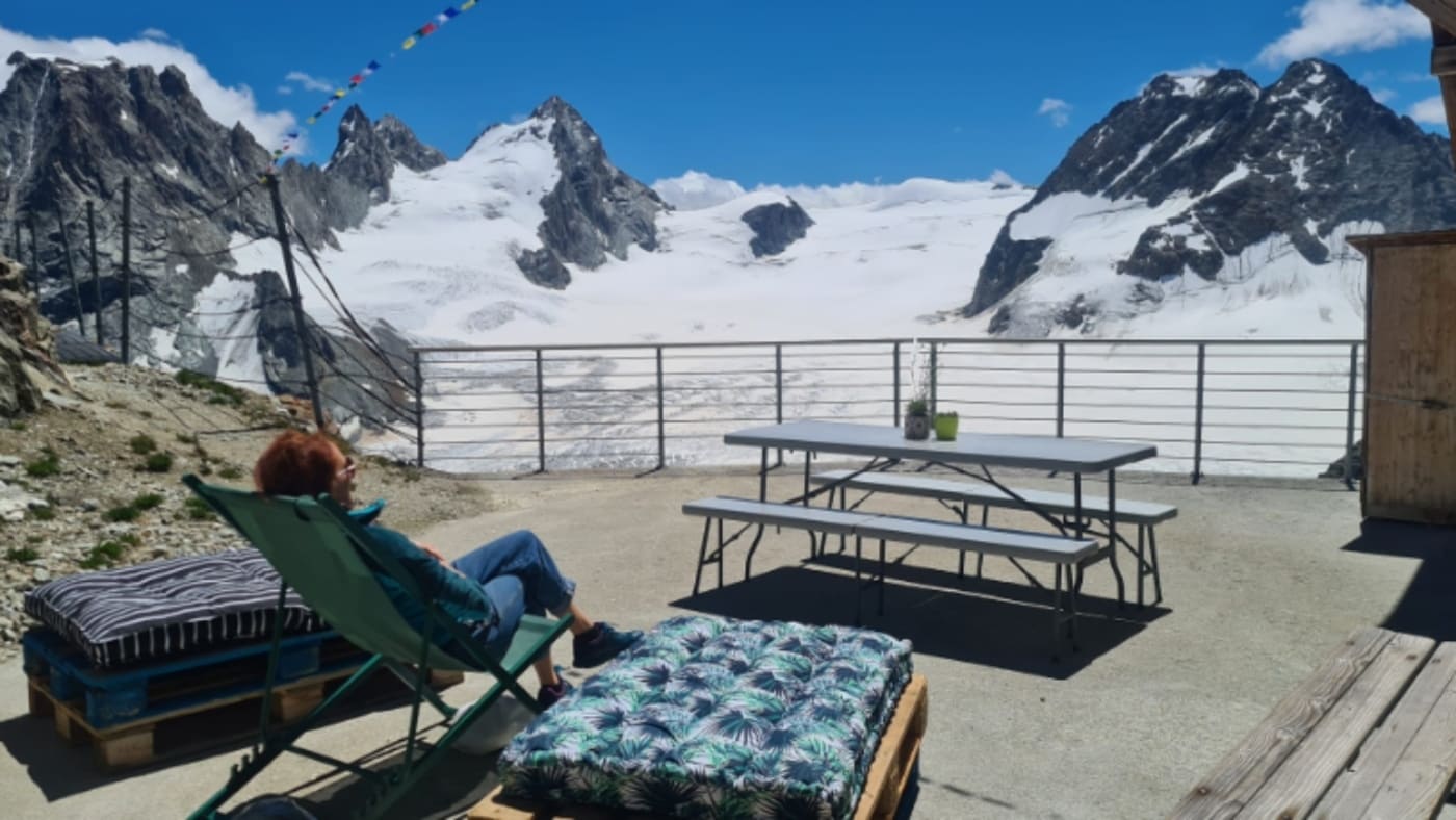 A person relaxing in a lounge chair outside a mountain in the Alps with B4Experience