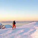 A skier enjoys the snowy peaks in Lofoten sea with B4Experience