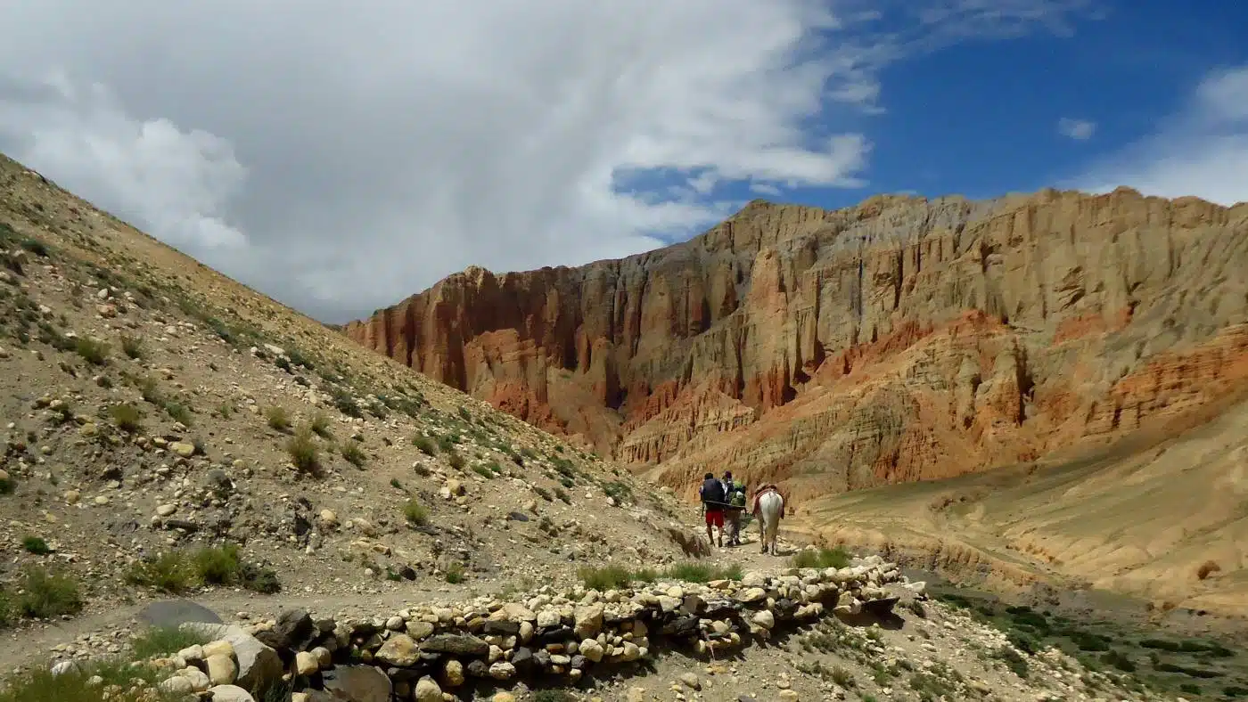 Group of trekking exploring the striking red cliffs of Mustang Dhakmar - B4Experience