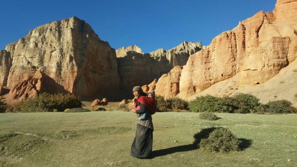 A local woman carrying a child in Mustang, Nepal - B4Experience