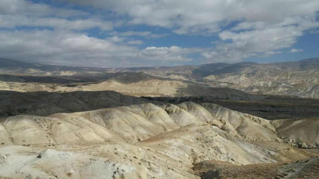 Vast, rolling desert hills of Upper Mustang under a dramatic sky - B4Experience