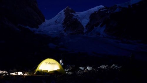 Glowing tent under a dark mountainous sky in Pakistan with B4Experience